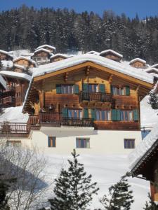 a large wooden building with snow on the roof at Chalet Etoile in Grimentz