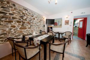 comedor con mesas y sillas y pared de piedra en Arhontiko Prepala, en Neochori