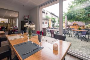 een eetkamer met een tafel en een groot raam bij Hôtel Restaurant Notre Dame in Haguenau