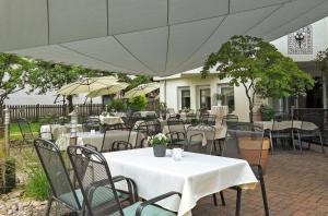 an outdoor patio with tables and chairs and an umbrella at Hotel-Gasthaus Adler in Schopfheim