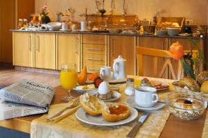 a table with a breakfast of oranges and orange juice at Hotel-Gasthaus Adler in Schopfheim