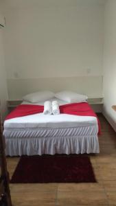 1 dormitorio con 1 cama con 2 toallas en Pousada Dona Quiteria, en Penha