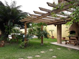 a wooden pergola with a bench in a yard at Pousada Hostel Brazil Backpackers in Guarujá
