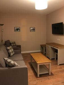 a living room with a couch and a table and a television at Nort Bode Apartments in Lerwick