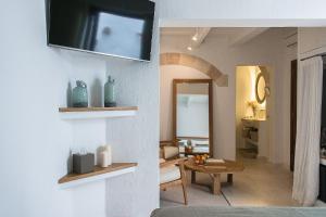 un soggiorno con TV a parete di S'Hotelet d'es Born - Suites & SPA a Ciutadella