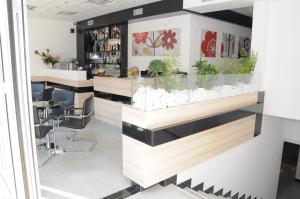 un bar en un restaurante con plantas en el mostrador en Garni Hotel Consul, en Niš