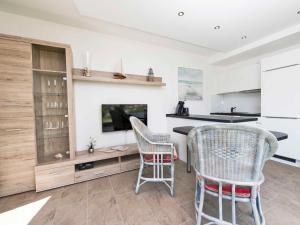 una cucina con due sedie e un tavolo con tv di Villa "Ars Vivendi" F641 - WG 2 mit Terrasse a Binz