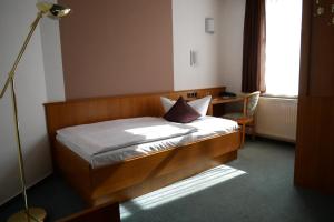 a small bedroom with a bed and a desk at Hotel Garni Brauhof Niederwiesa in Niederwiesa