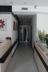 einen Flur eines Bürogebäudes mit Bänken in der Unterkunft Garni Hotel Consul in Niš
