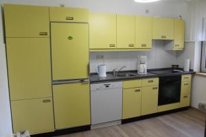 a kitchen with yellow cabinets and a sink at Ferienhaus Laydeckersch in Mastershausen