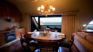 uma sala de jantar com uma mesa e uma grande janela em Apartamento Area Mayor em Malpica de Bergantiños