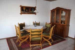 a dining room with a table and chairs and a cabinet at Ferienhaus Laydeckersch in Mastershausen