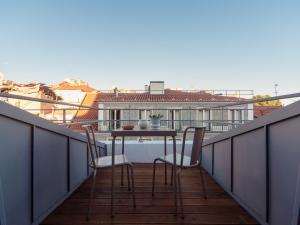 a balcony with a table and chairs on a roof at Dear Lisbon - Gallery House in Lisbon
