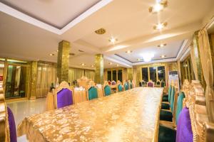 una mesa larga y sillas en un salón de banquetes en Nakaraj Princess Chiang Rai - Walking Street, en Chiang Rai