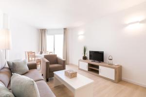 a living room with a couch and a tv at Marina Palace by Intercorp Hotel Group in San Antonio Bay