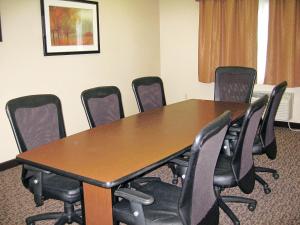 een conferentieruimte met een houten tafel en stoelen bij Savanna Inn & Suites in Savanna