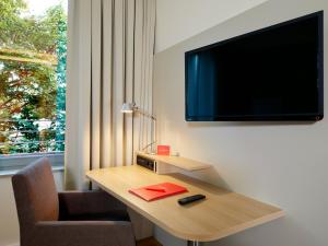 Televízia a/alebo spoločenská miestnosť v ubytovaní Flottwell Berlin Hotel & Residenz am Park