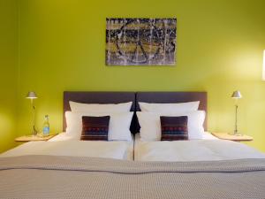 
a bed with a white bedspread and pillows at Flottwell Berlin Hotel & Residenz am Park in Berlin
