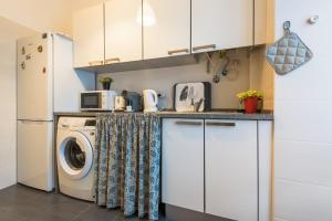 a kitchen with a washing machine and a refrigerator at Bhappy@home Lisboa in Lisbon