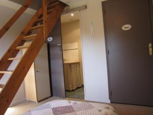 a bedroom with a staircase leading to a bathroom at L'ECURIE GITE in La Pommeraye