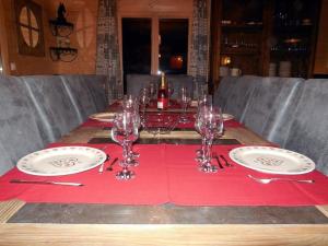 una mesa con copas de vino en un mantel rojo en Arbroz, en La Côte dʼArbroz