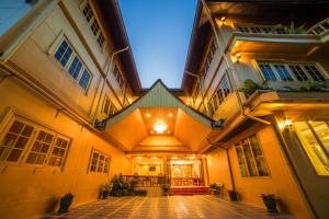 un edificio antiguo con un patio iluminado por la noche en Nakaraj Princess Chiang Rai - Walking Street, en Chiang Rai