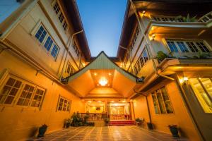 an old building with a lit up courtyard at night at Nakaraj Princess Chiang Rai - Walking Street in Chiang Rai