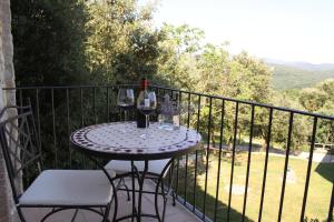 a table with two glasses of wine on a balcony at El Mirador del Bosqueró in Les Planes d'Hostoles