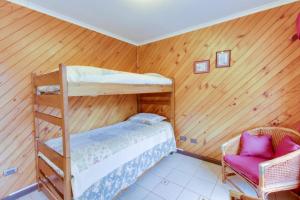 a bedroom with two bunk beds and a chair at Apart Hotel Blumenau in Osorno