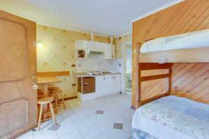 a bedroom with a bunk bed and a kitchen at Apart Hotel Blumenau in Osorno