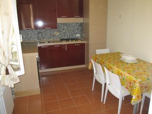 a kitchen with a table with white chairs and a tablecloth on it at La Dimora di Nadine in La Spezia