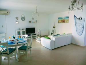 uma sala de estar com um sofá branco e uma mesa em Apartments For You em Olimp