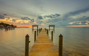 a wooden dock in the water with a sunset at Drift Hotel in Key Largo