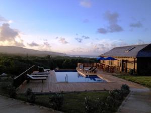 a villa with a swimming pool and a house at Santosha Barbados in Saint Andrew