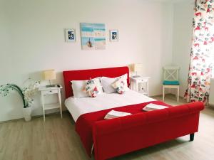 a red couch in a living room with a bed at Apartments For You in Olimp