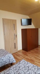a bedroom with a bed and a television on the wall at Noclegi Na Wzgórzu in Krajno Pierwsze