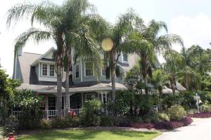 a house with palm trees in the front yard at Heron Cay Lakeview Bed & Breakfast in Mount Dora