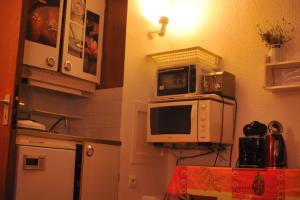 a kitchen with a microwave on top of a refrigerator at Studio Les Menuires Brelin in Les Menuires