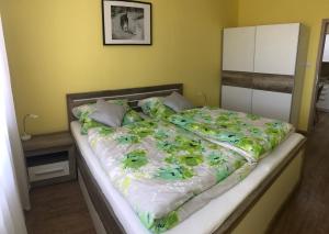 un grande letto con piumone verde e bianco di Apartman illy a Veľký Slavkov