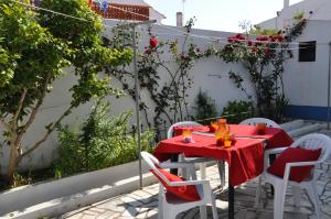 una mesa roja y sillas en un patio en Apartamentos Campos 0 en Porto Covo