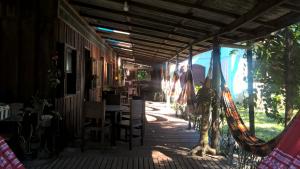 una veranda di una casa con tavolo e sedie di Pousada Trilha do Farol a Ilha do Mel