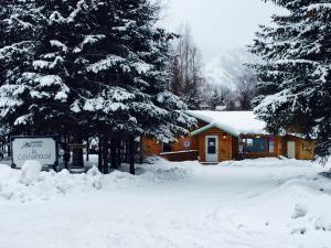 una cabaña en la nieve con árboles y un cartel en Hope's Hideaway, LLC, en Hope