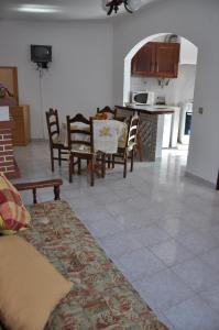 ein Wohnzimmer mit Stühlen und einem Tisch sowie eine Küche in der Unterkunft Apartamentos Campos 1 in Porto Covo