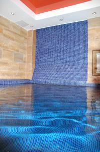 una piscina con una pared de azulejos azules en Hotel 55 Shirota, en Novosibirsk