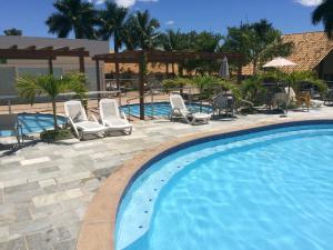 - une piscine avec des chaises longues et un complexe dans l'établissement Apartamento Caldas Novas, à Caldas Novas