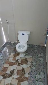 a bathroom with a toilet on a tiled floor at Lanta Local Hut in Ko Lanta