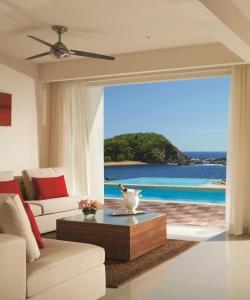 a living room with a view of the ocean at Secrets Huatulco Resort & Spa in Santa Cruz Huatulco