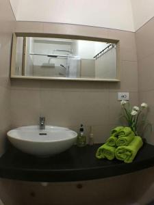 a bathroom with a sink and a mirror and towels at AMS Staycation at Wind Residences in Tagaytay