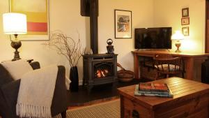 a living room with a fireplace and a tv at Coach House in Port Fairy