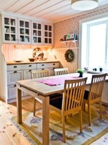 cocina con mesa de madera y sillas en STF Kungsgården Långvind, en Enånger